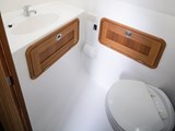 Electric flush lavatory with holding tank in a forward cabin with room to change.